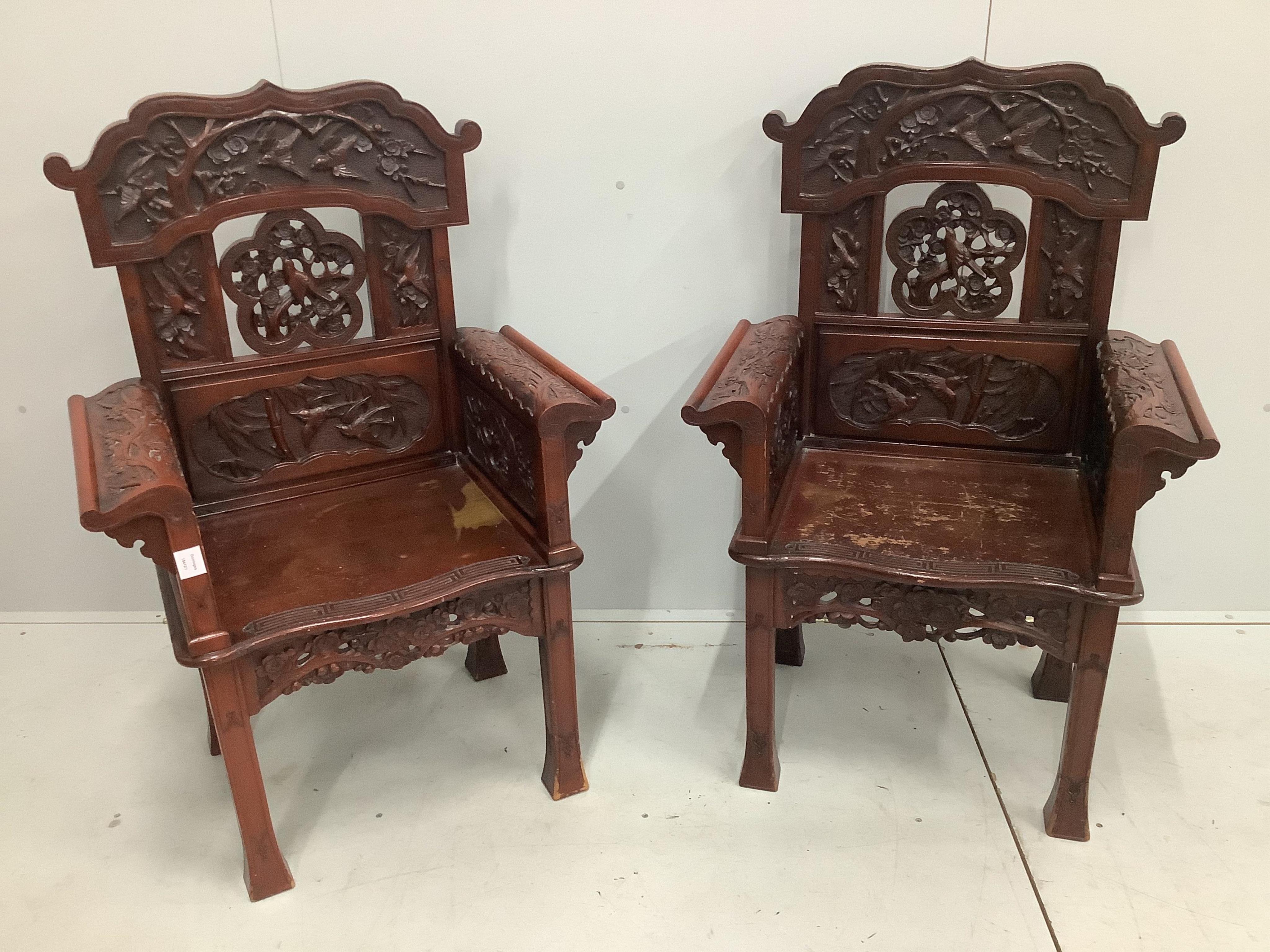 A pair of Chinese carved hardwood armchairs, width 73cm, height 111cm. Condition - rather worn in places